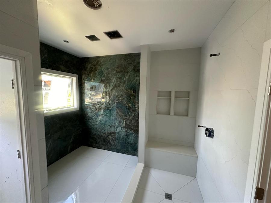 Dark green porcelain walk-in shower with frameless glass by Silcam Tile Installation, New Jersey